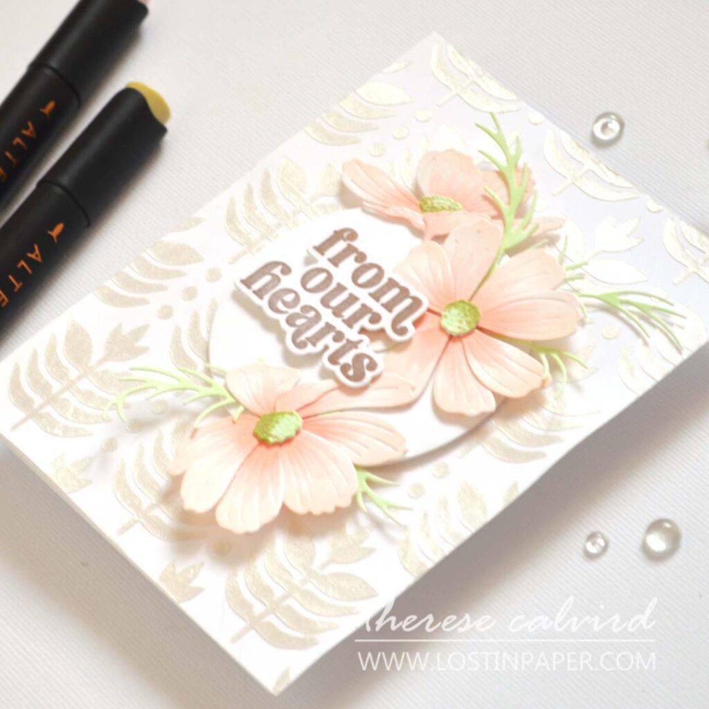 Handmade card with layered Cosmos flowers as a central focal point on a textured background with sentiment