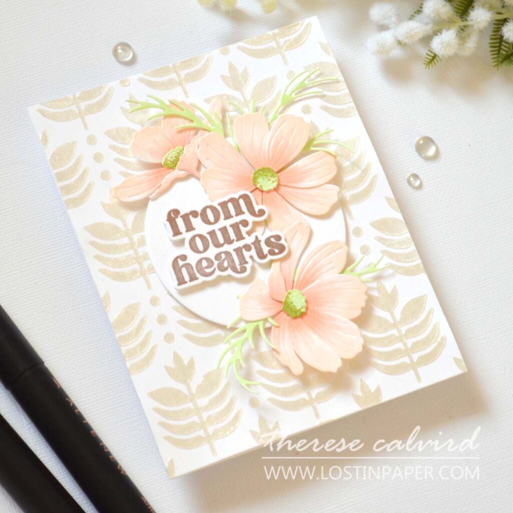 Handmade card with layered Cosmos flowers as a central focal point on a textured background with sentiment
