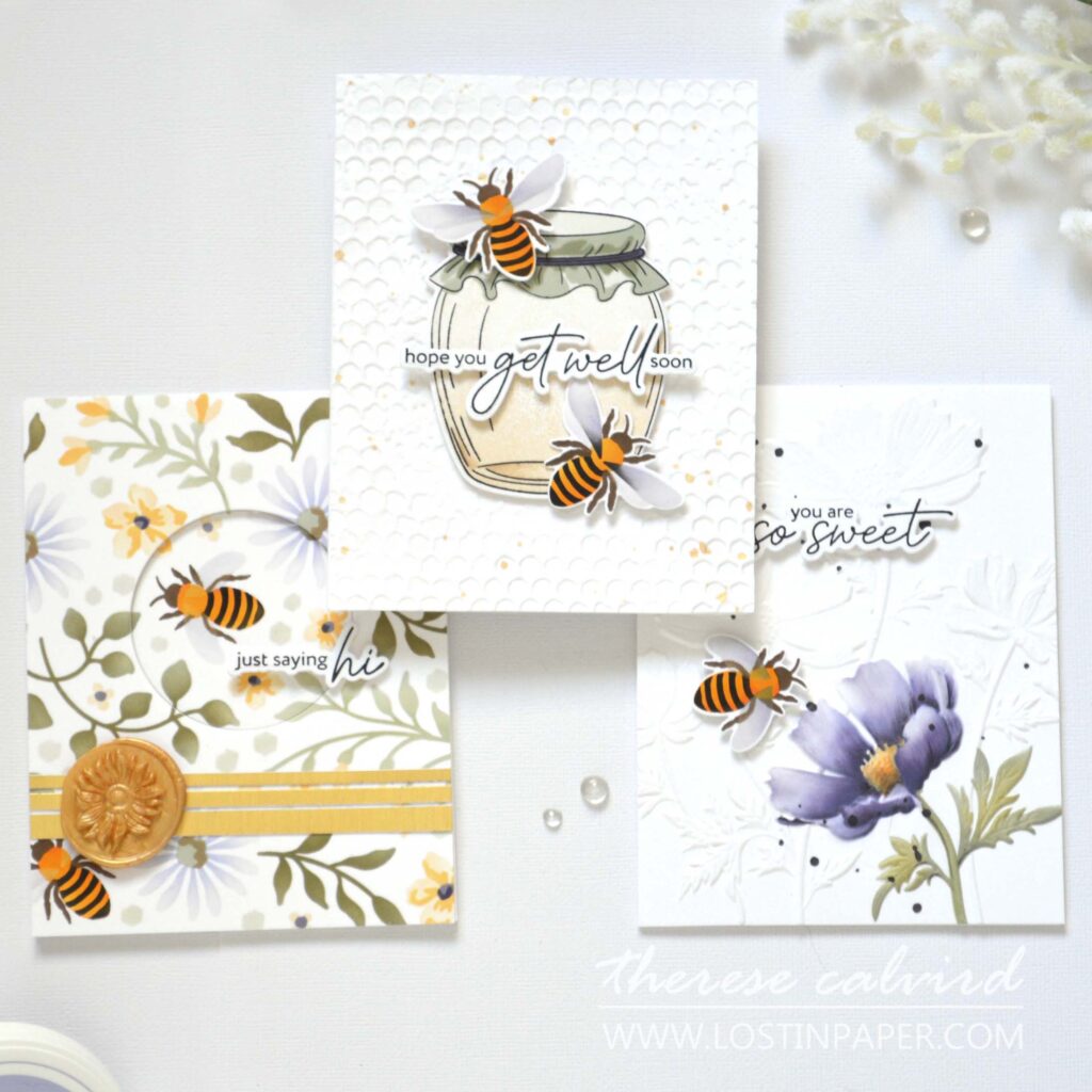 Three handmade focal point cards showcasing different techniques: honey jar with 3D embossed background, partially colored flower with stencil, and floral stencil background with recessed circular window and bee
