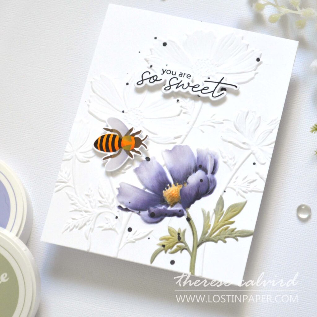 Focal point card with 3D embossed background, one flower colored using a stencil, a small bee accent, and optional coloring with markers, pencils, or paints