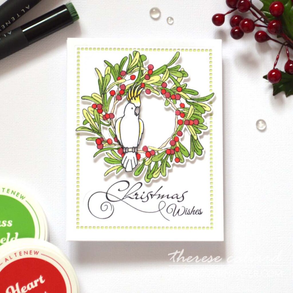 Stamped and alcohol-marker colored bird on a stamped and ink-blended wreath, stepped up with a cockatoo and a die-cut negative space border