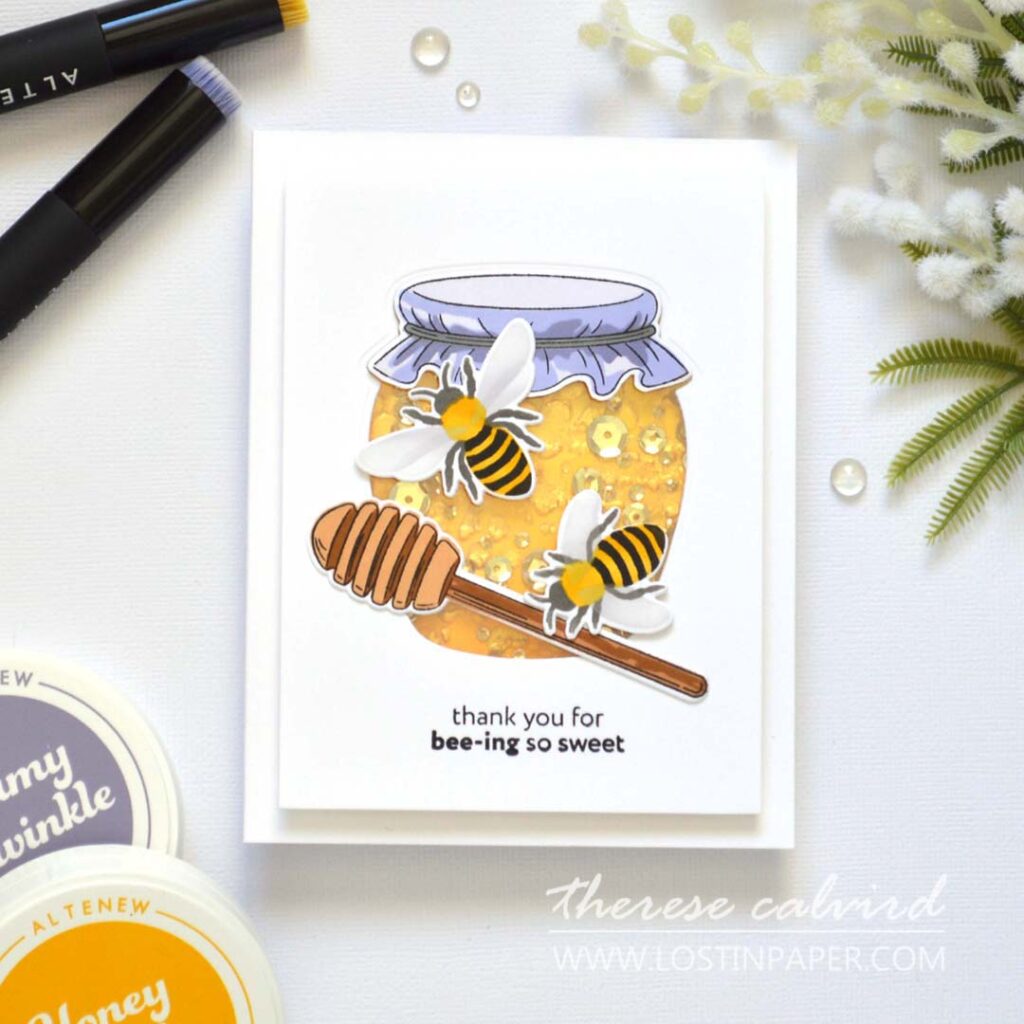 Shaker card designed as a honey jar, with embossed honeycomb background, gold highlights, and sparkling golden sequins.