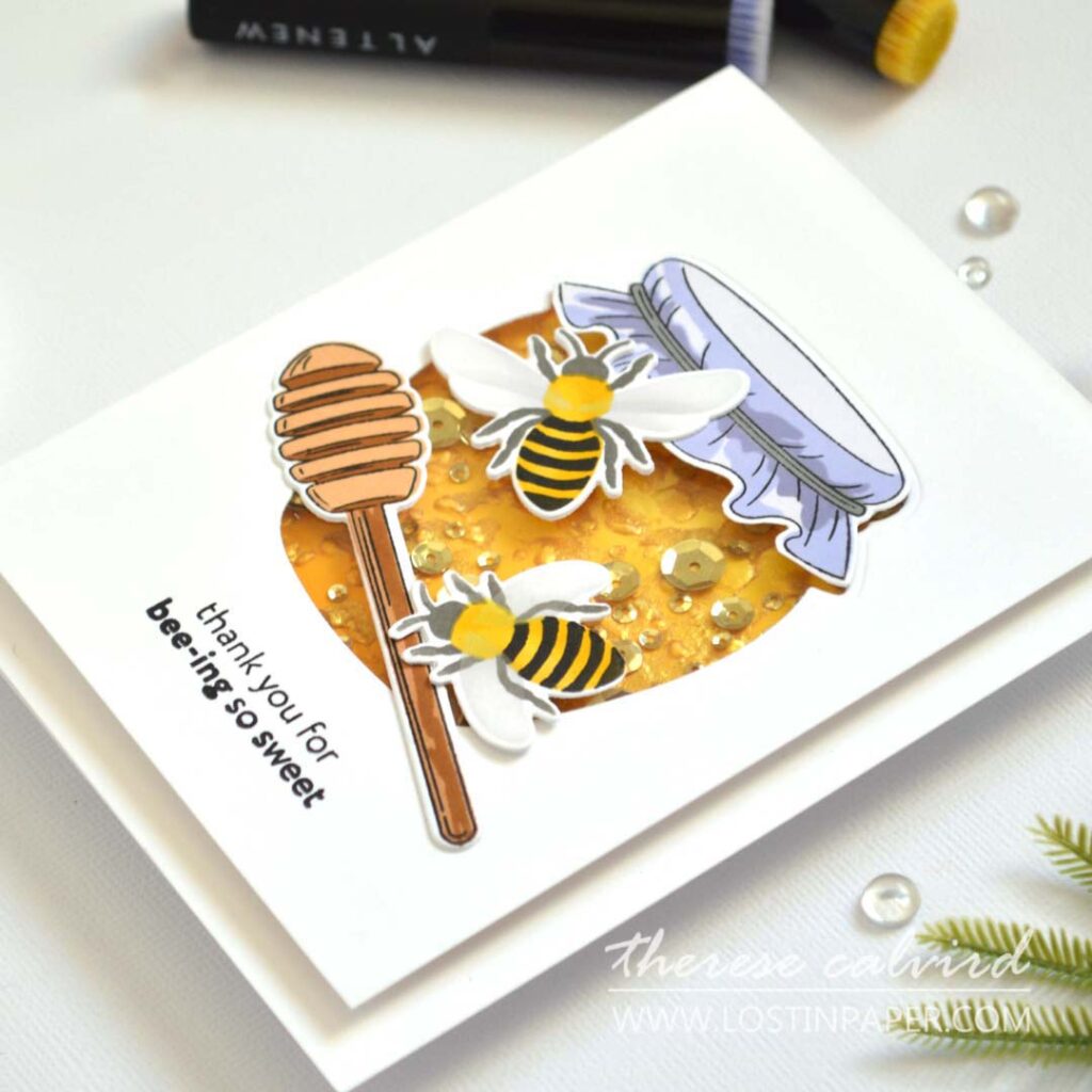 Shaker card designed as a honey jar, with embossed honeycomb background, gold highlights, and sparkling golden sequins.