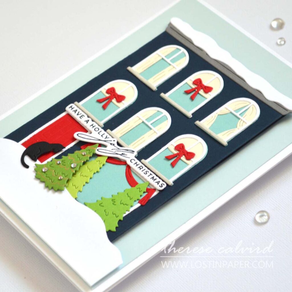 Jolly Christmas house card featuring a die-cut city building with a black cat at the front door by Therese Calvird.