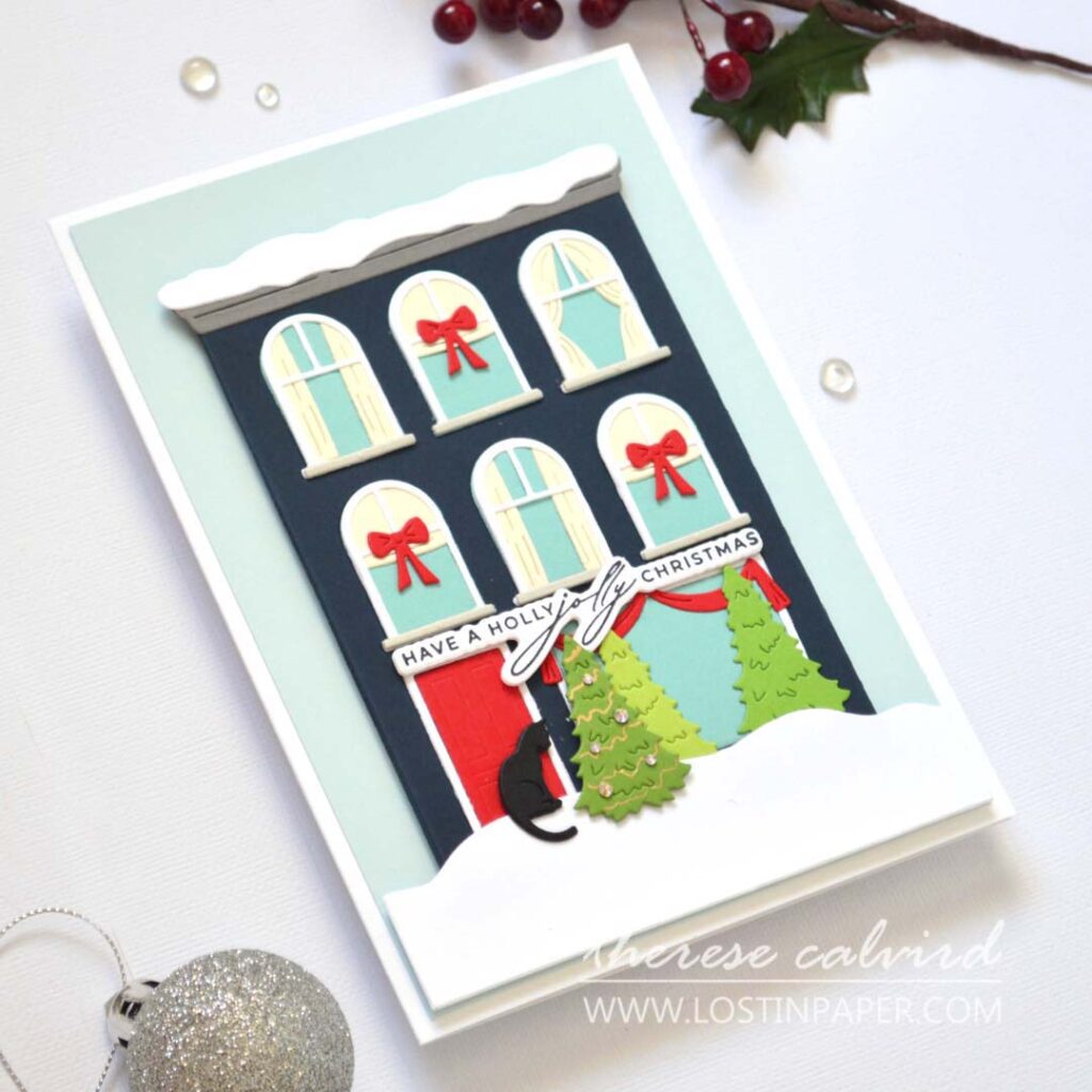 Jolly Christmas house card featuring a die-cut city building with a black cat at the front door by Therese Calvird.