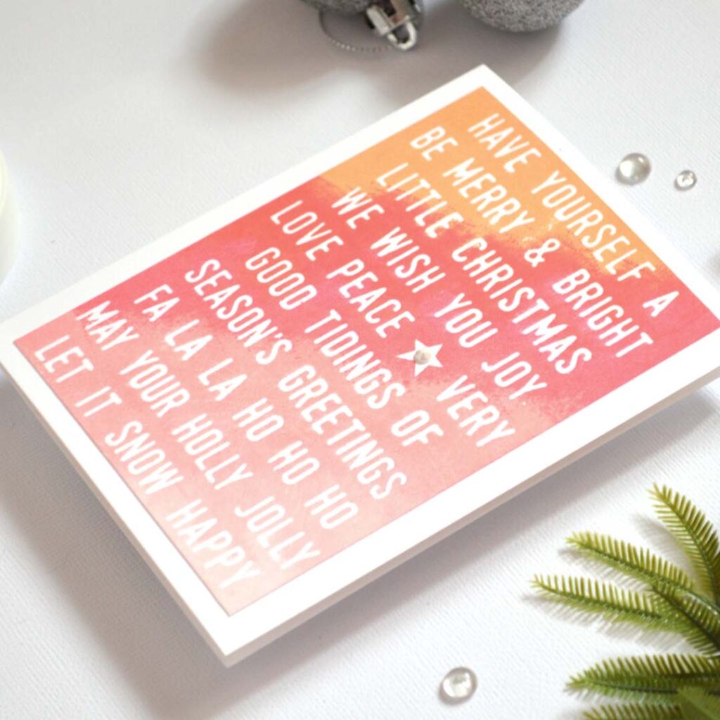 Handmade Christmas card from Therese Calvird’s Same But Different Christmas series with a multi-sentiment background ombre-stamped in red and pink tones.