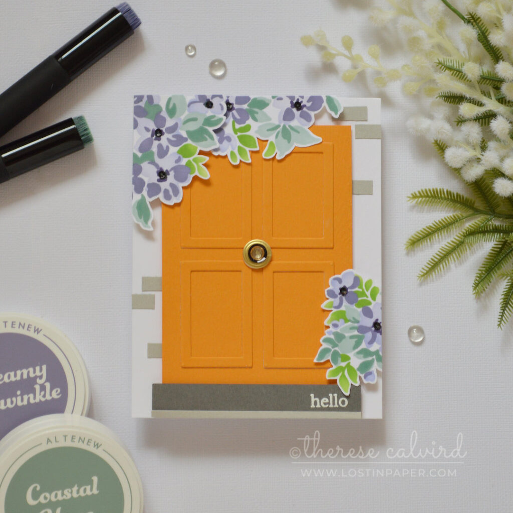 Bright orange door card with small picture frames used as wood panels, decorated with flowers and a rhinestone door knob by Therese Calvird