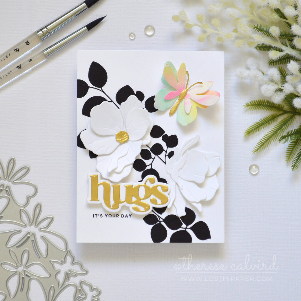 Modern black and white leaf background with a single layered rainbow butterfly white die cut flowers and a gold sentiment Therese Calvird