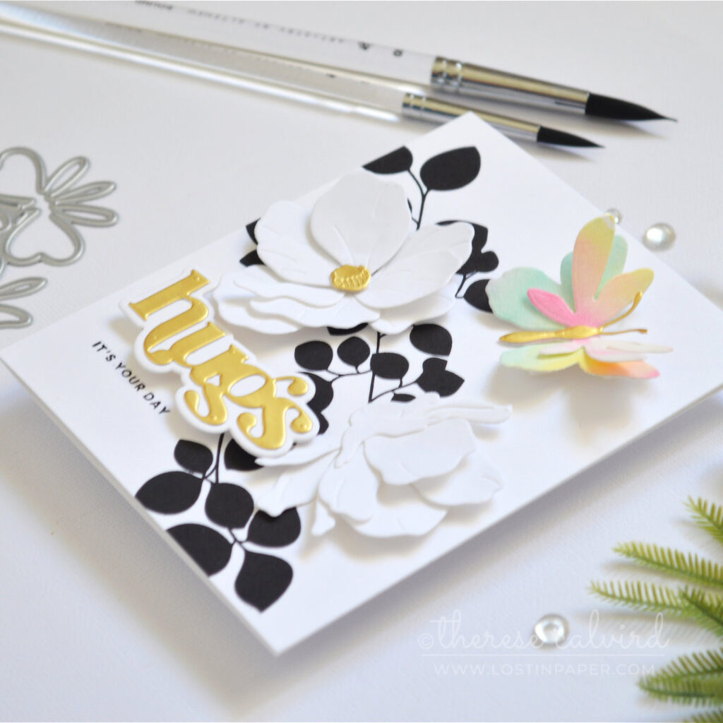 Modern black and white leaf background with a single layered rainbow butterfly white die cut flowers and a gold sentiment Therese Calvird