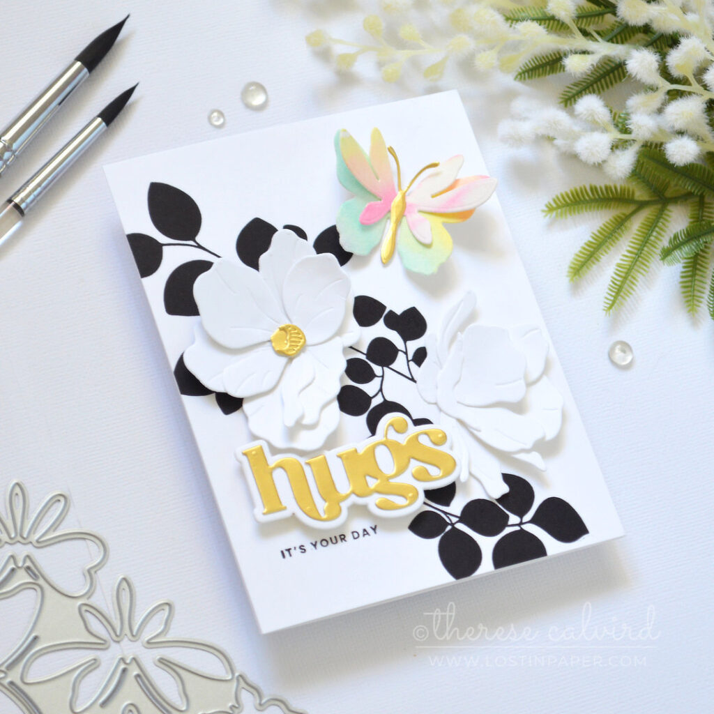 Modern black and white leaf background with a single layered rainbow butterfly white die cut flowers and a gold sentiment Therese Calvird
