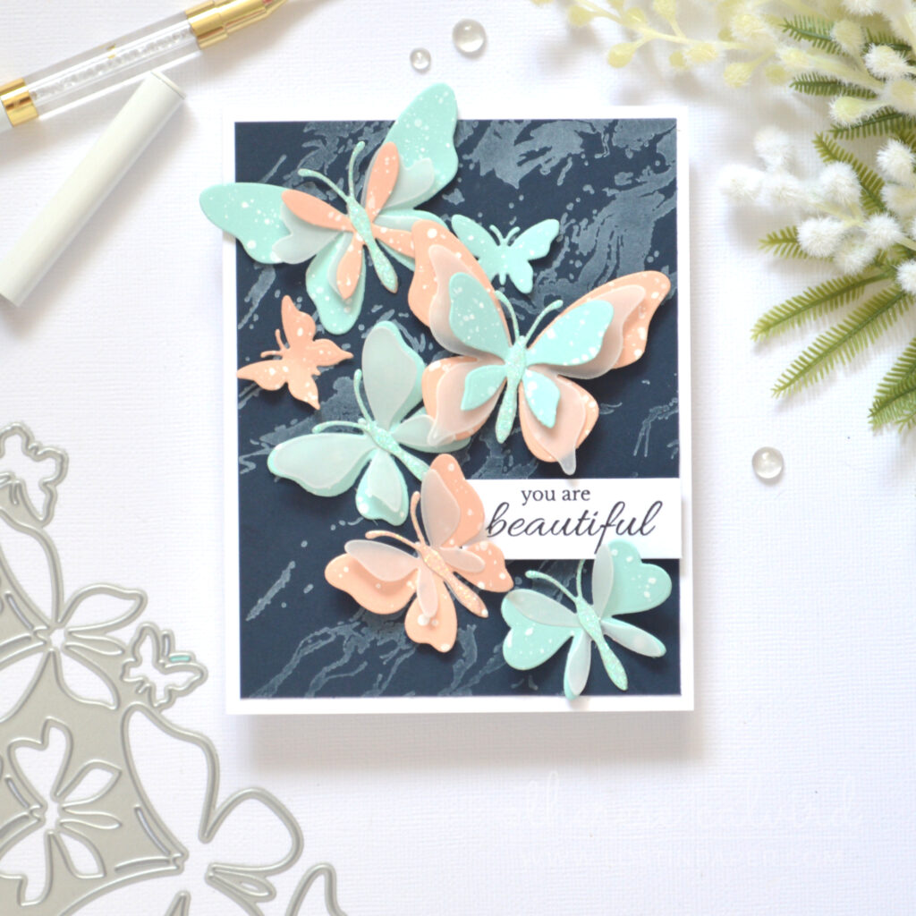 Layered butterfly die cut card with pastel colours vellum and glitter on navy by Therese Calvird