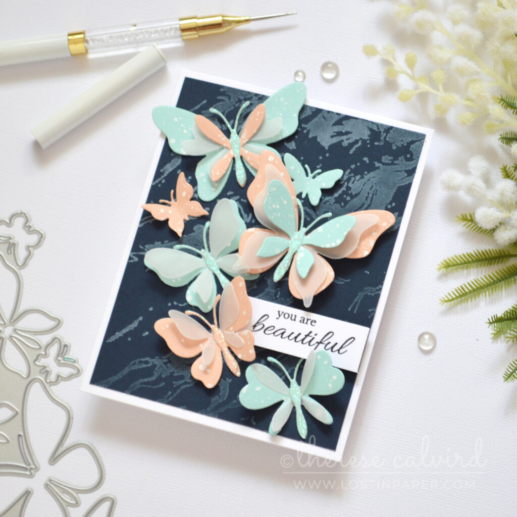 Layered butterfly die cut card with pastel colours vellum and glitter on navy by Therese Calvird