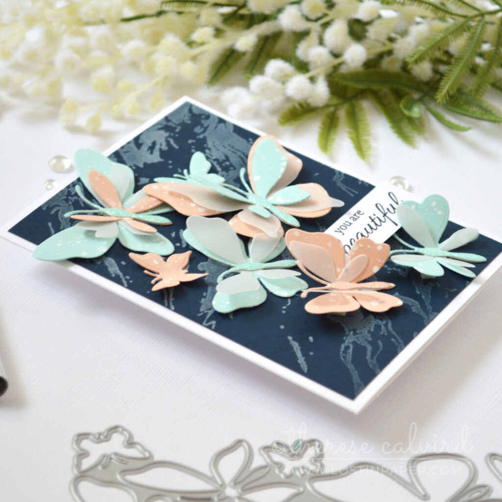 Layered butterfly die cut card with pastel colours vellum and glitter on navy by Therese Calvird
