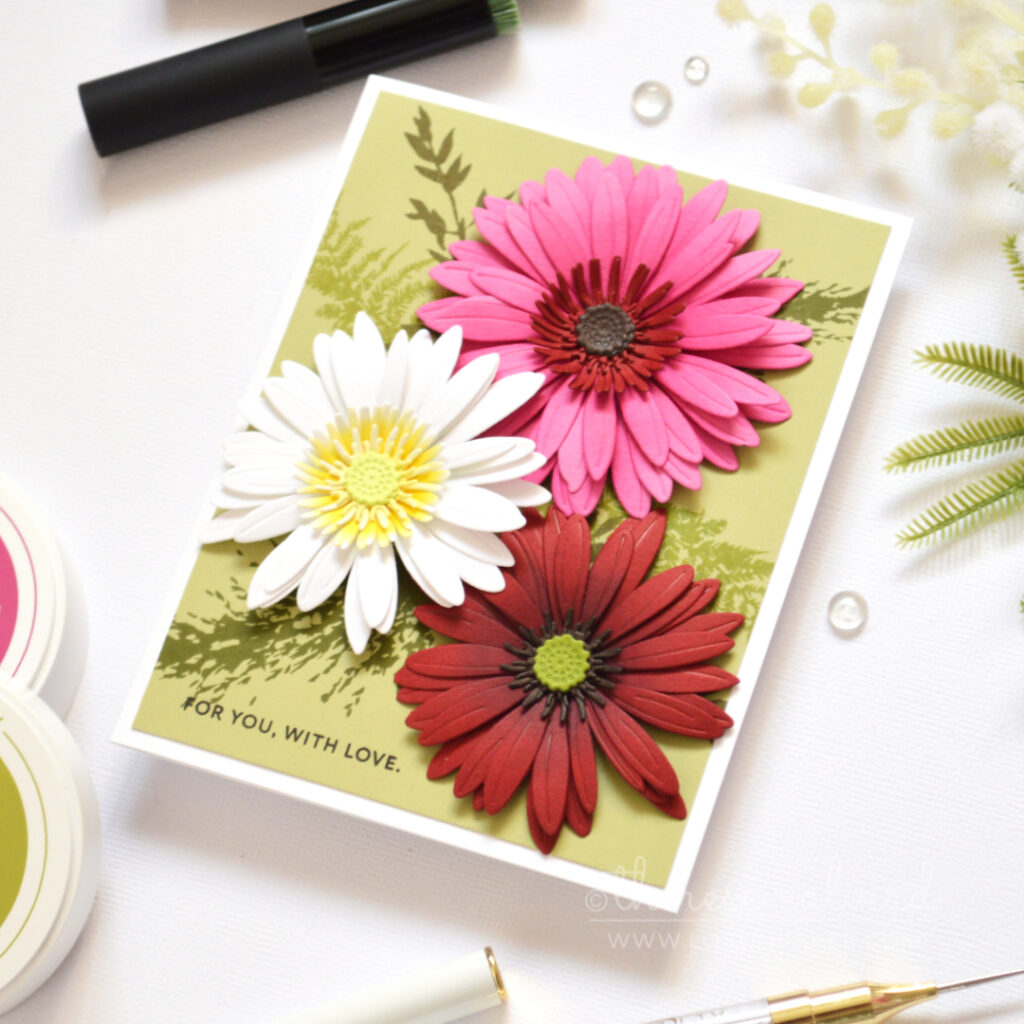 Bright gerbera floral card made with altered layering dies and a tone-on-tone leafy stamped background.