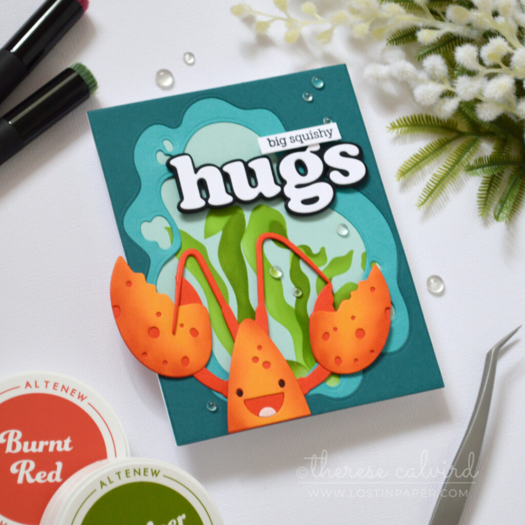 Handmade lobster hugs card with an ocean window frame, seaweed background, and large die cut sentiment.