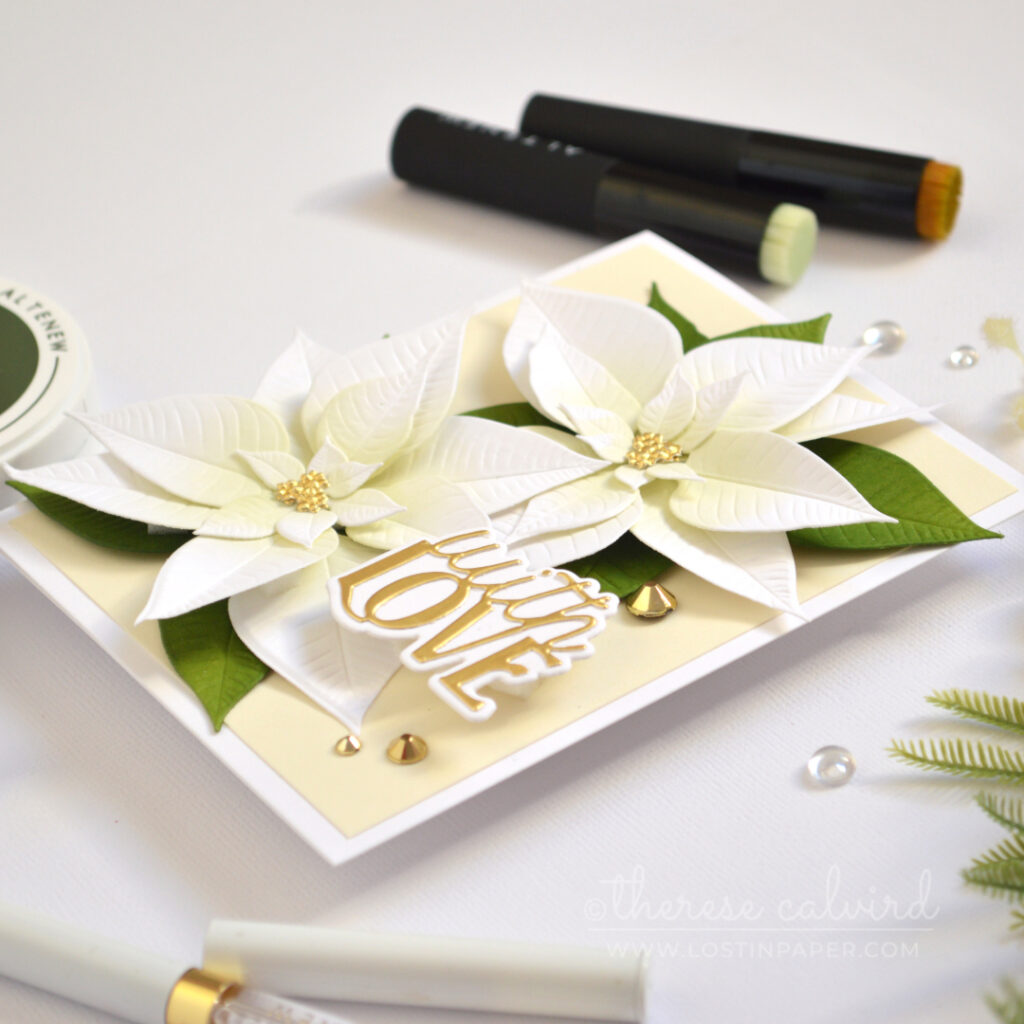 Handmade card with layered white die-cut poinsettias, soft pistachio green ink blending, golden accents, and a layered die-cut sentiment.