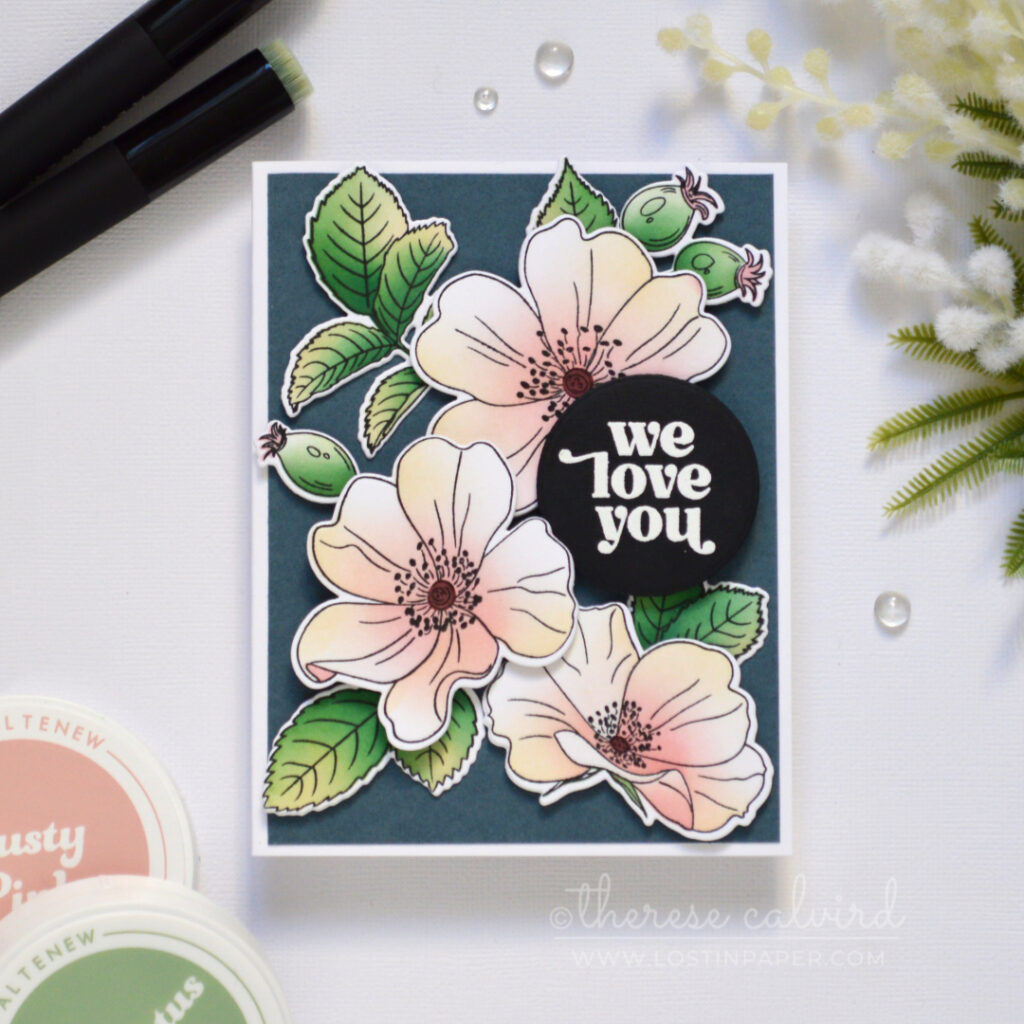 Pastel one go floral card with ink-blended flowers and leaves on a dark blue-grey background.