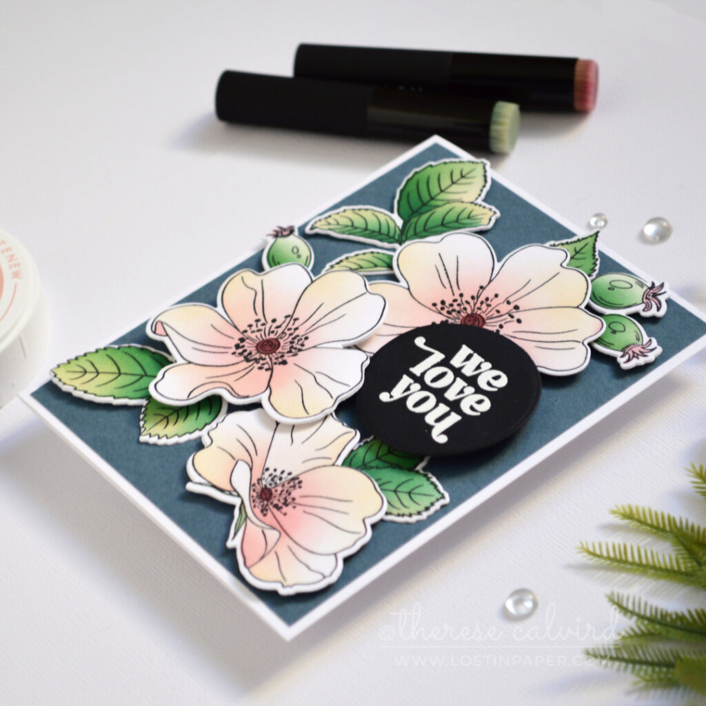 Pastel one go floral card with ink-blended flowers and leaves on a dark blue-grey background.