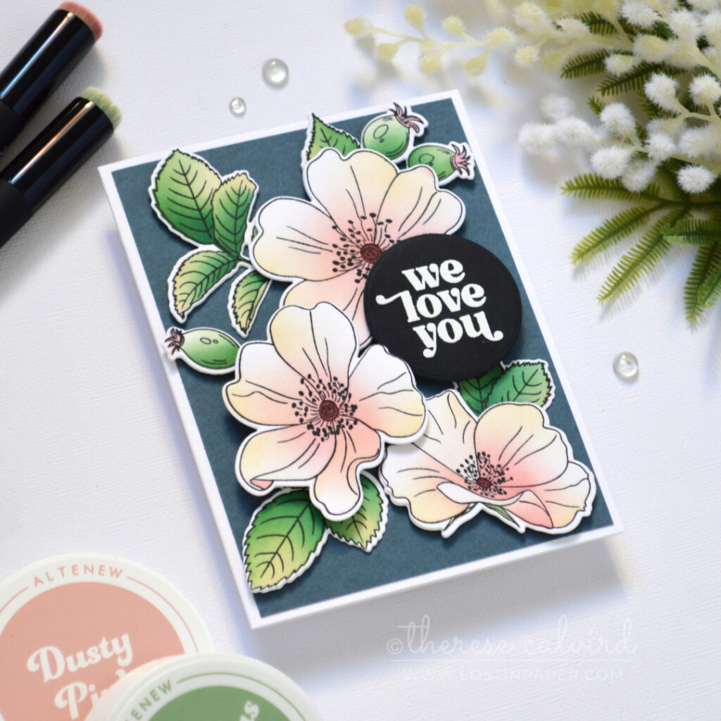 Pastel one go floral card with ink-blended flowers and leaves on a dark blue-grey background.