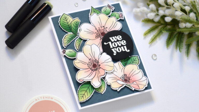 Pastel one go floral card with ink-blended flowers and leaves on a dark blue-grey background.