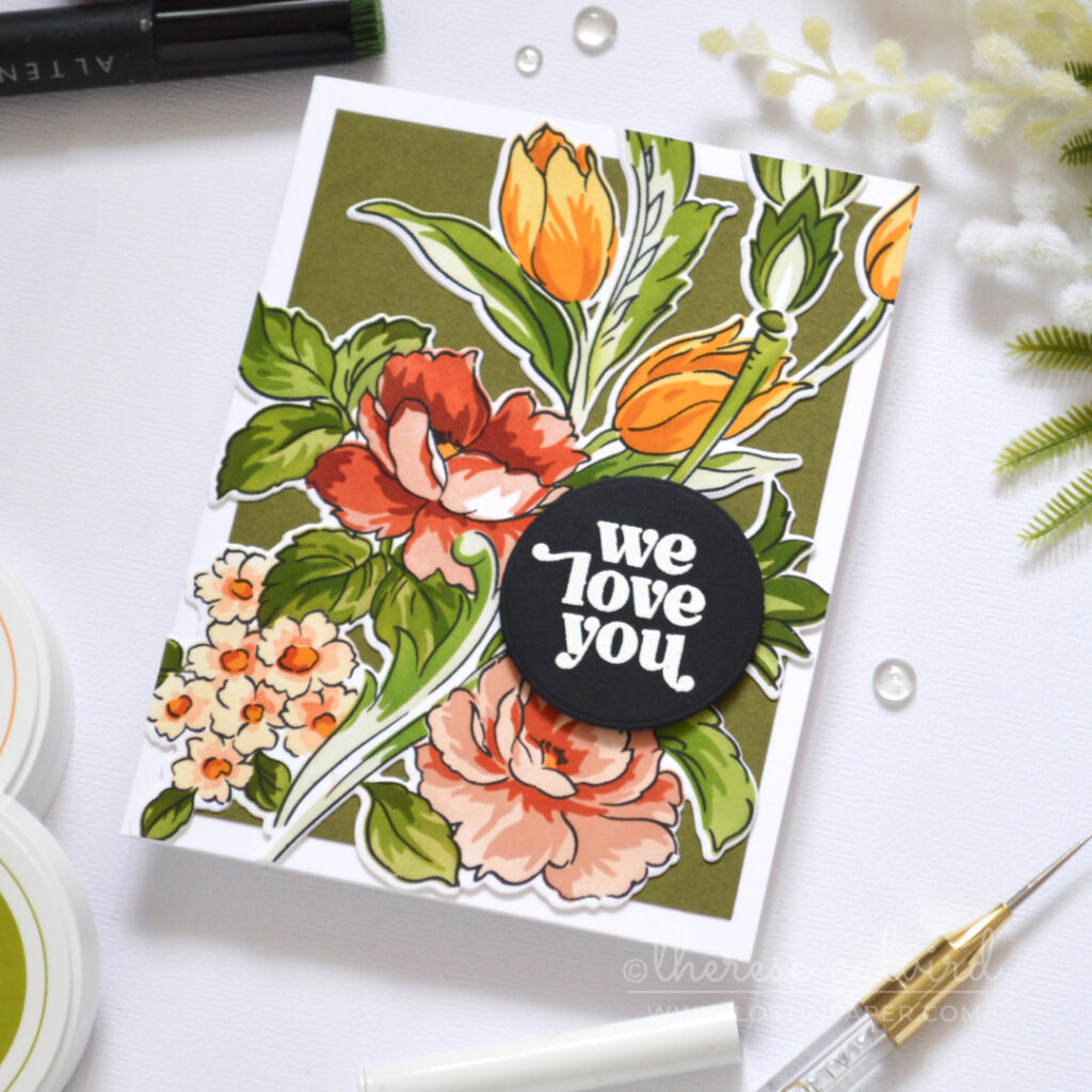Floral card in warm coral, gold and green tones with layered dimension and a white embossed sentiment on a black circle.