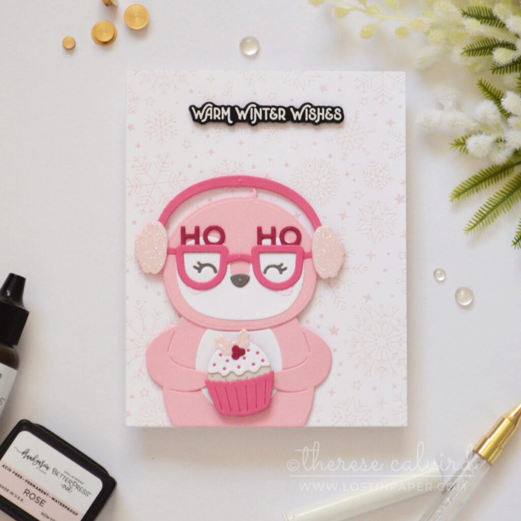 Pink penguin Christmas card with glitter earmuffs, spinning pudding and pale pink snowflakes.