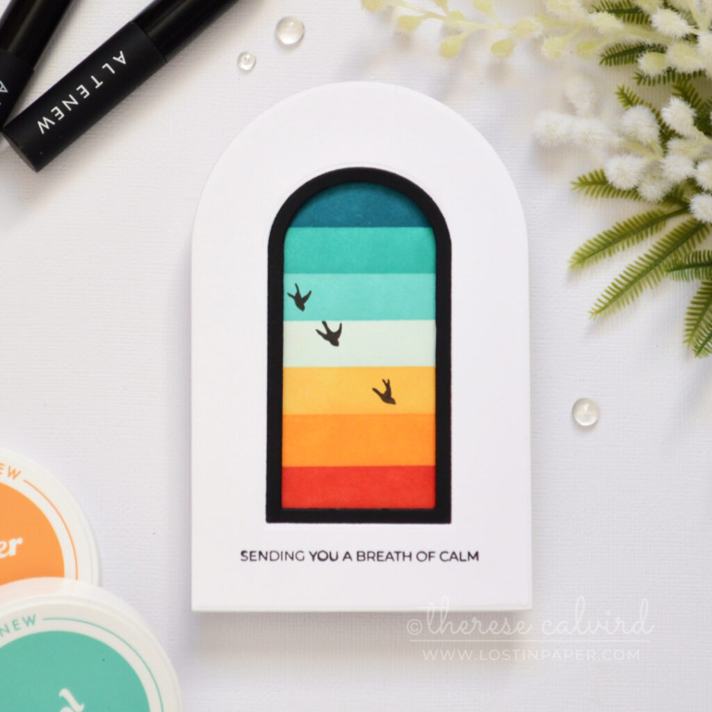 Top-fold arched shaped card with a masked retro rainbow window scene, black frame, and silhouette birds.
