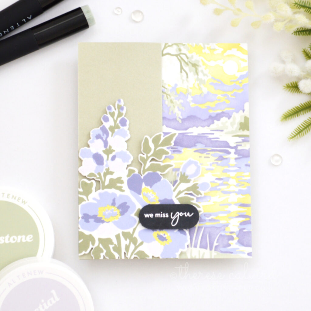 Sage green and purple floral Z-fold card with overhanging flowers, bold sentiment and a softly stenciled landscape background with yellow water reflection.