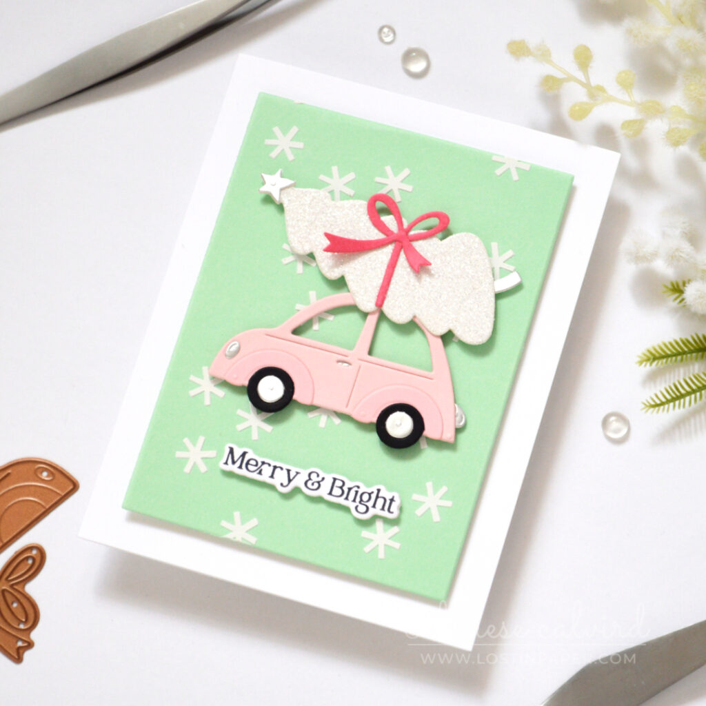 Mint Christmas card with white snowflake texture, pale pink car and glittery white tree.