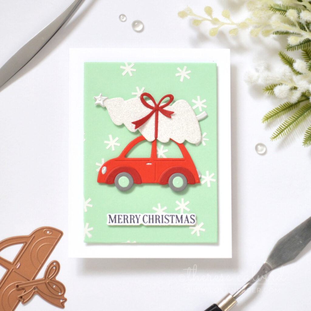 Mint Christmas card with white snowflake texture, bright red car and glittery white tree.