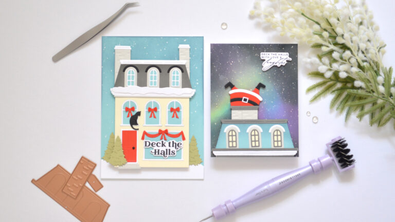 Cream City House Christmas card with grey Mansard roof, bright red door, snowy details, red window garlands and a black cat.