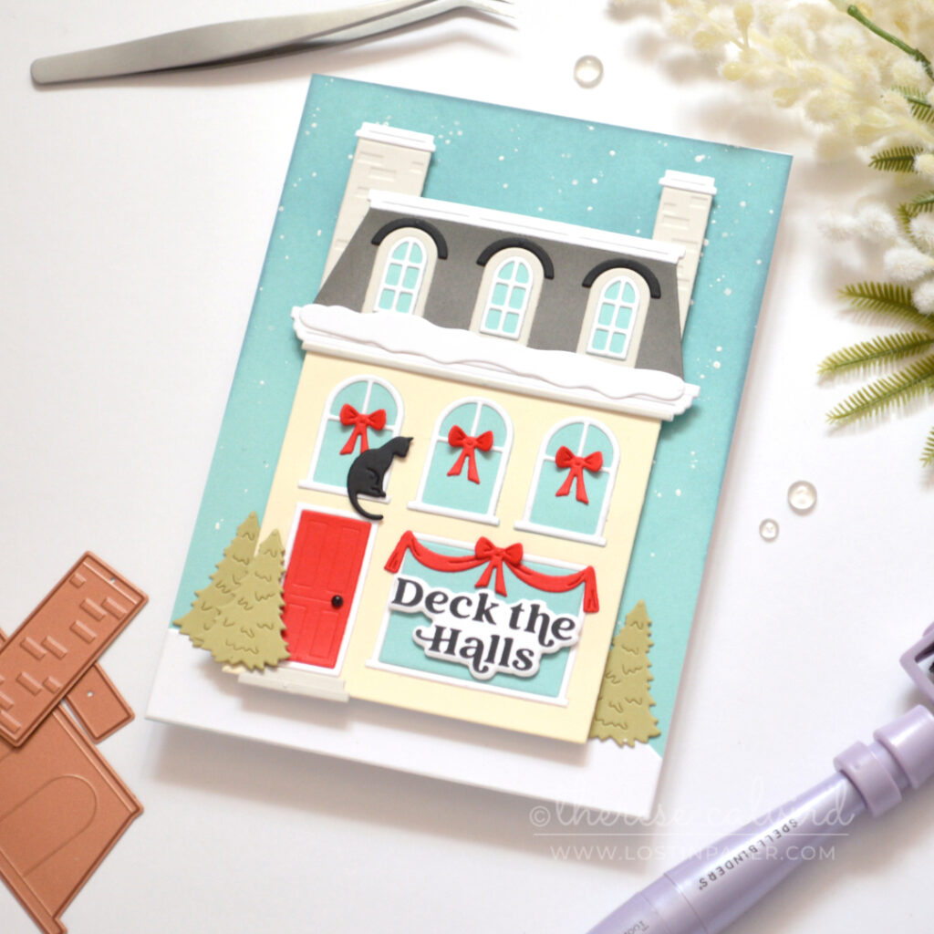 Cream City House Christmas card with grey Mansard roof, bright red door, snowy details, red window garlands and a black cat.