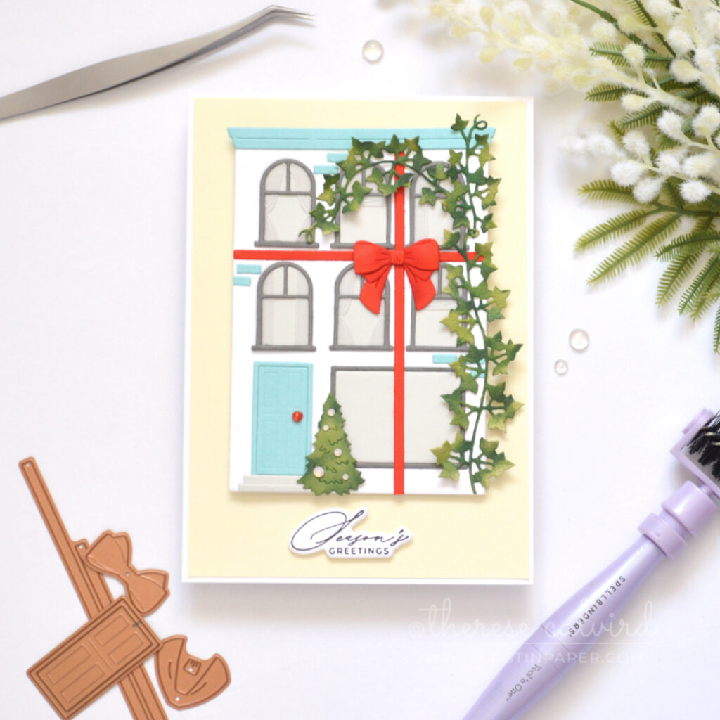 White City House Christmas card with blue roof and door, red bow, green vine, Christmas tree and vellum curtains.