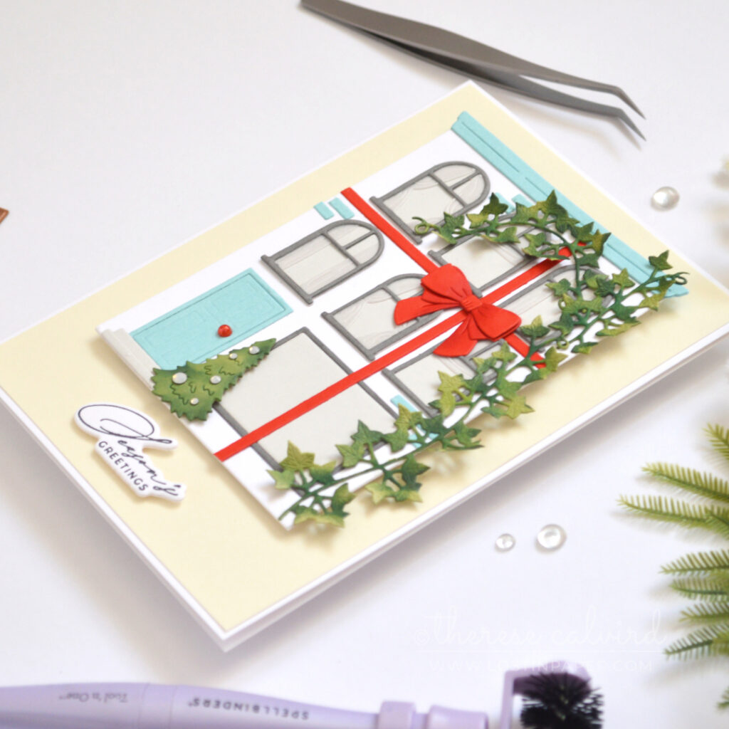 White City House Christmas card with blue roof and door, red bow, green vine, Christmas tree and vellum curtains.