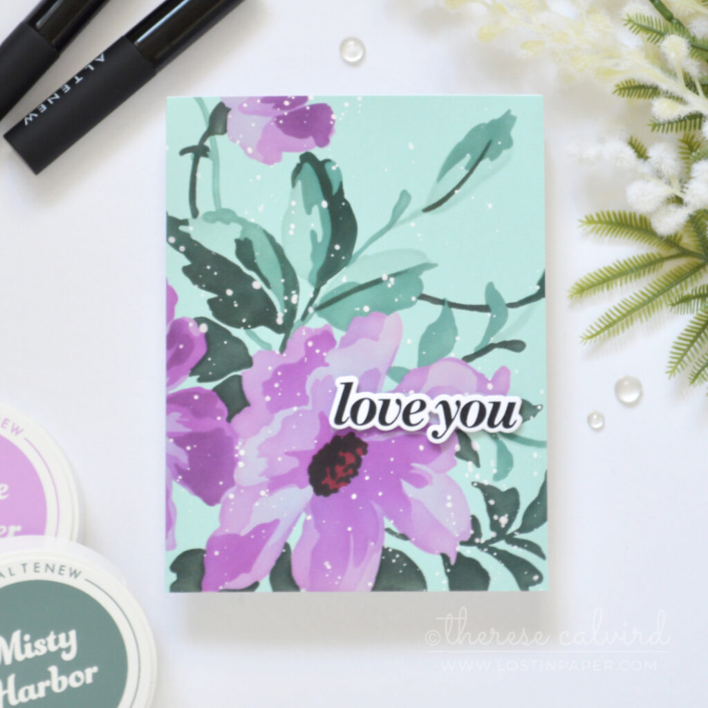 Handmade card with a large purple stenciled flower and teal foliage on pale teal cardstock, with a bold sentiment and white ink splatters.