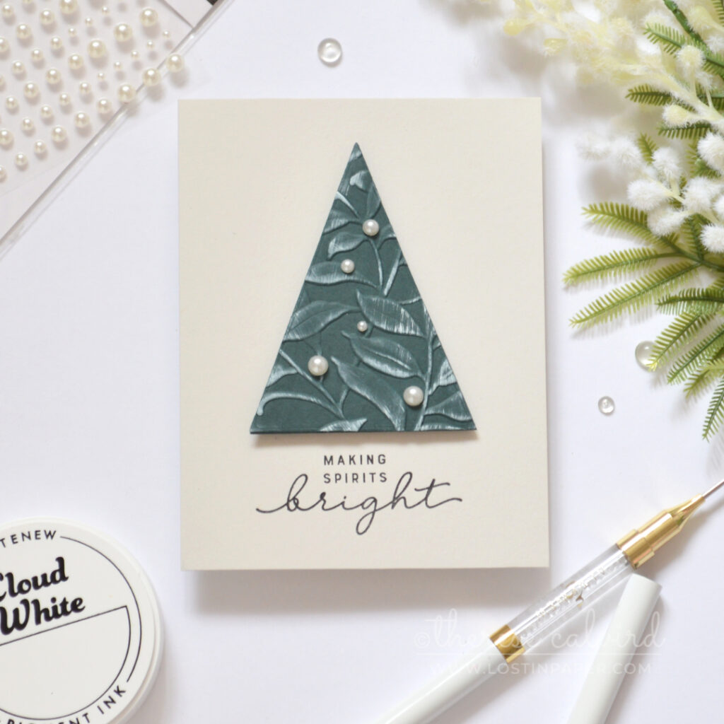 Modern Christmas card with an embossed foliage triangle tree and pearl accents.