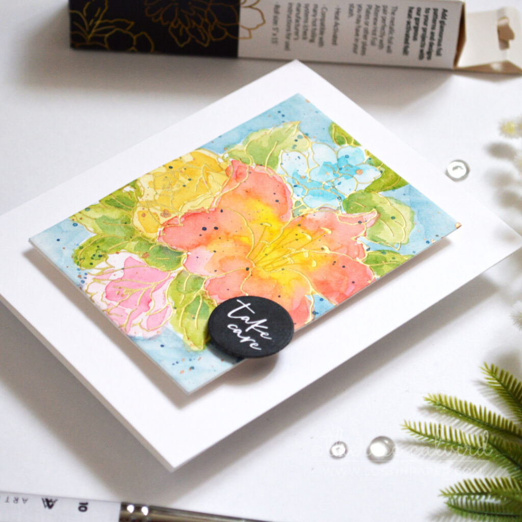 Hot foiled lily bouquet with loose, colourful watercolour and metallic splatters.